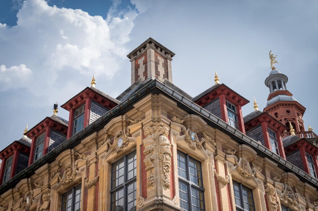 Les détails de la façade richement décorée de la Vieille Bourse de Lille, joyau de l’architecture flamande du XVIIe siècle, avec ses ornements sculptés et son toit aux couleurs vives.